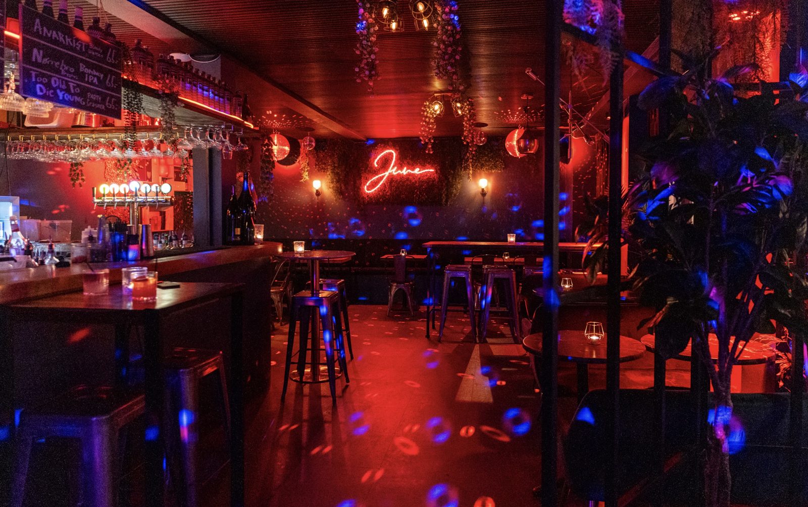 Indenfor på JUNE med bar, små borde og varmt lys