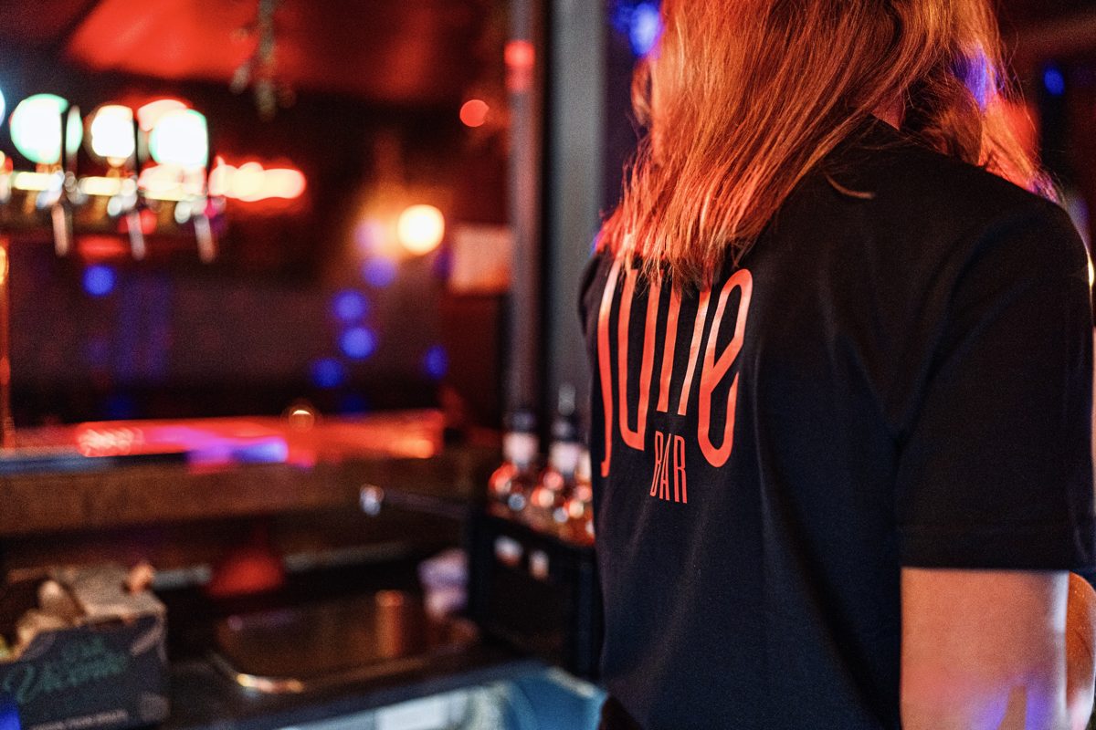 Medarbejder i JUNE BAR-trøje bag baren